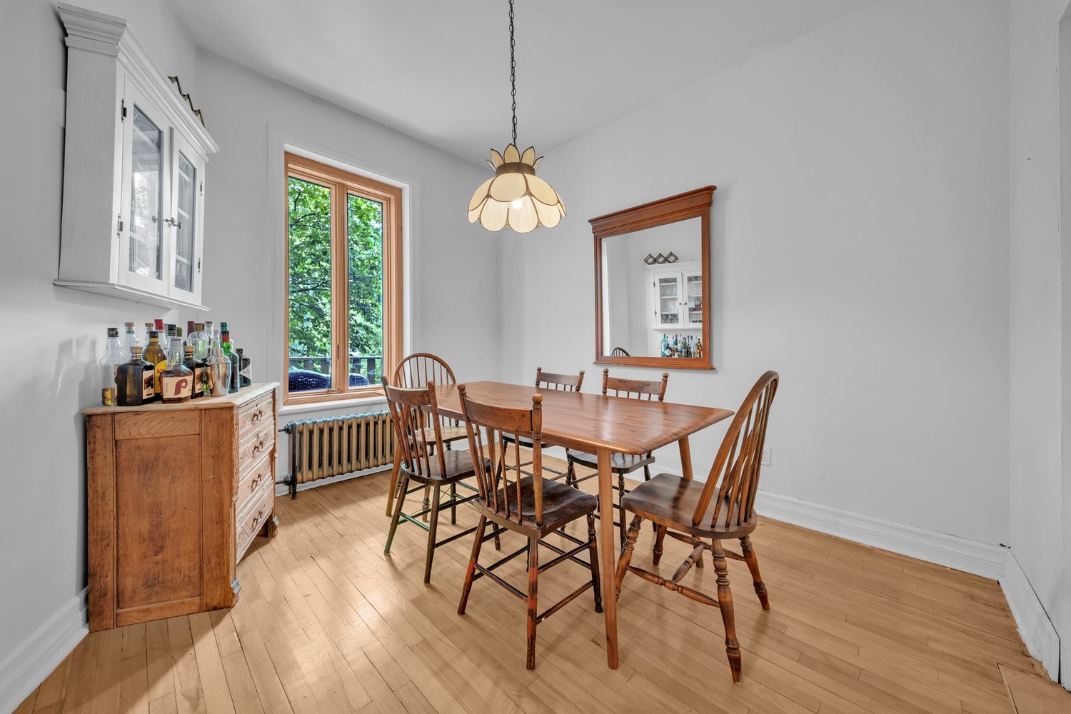 Dining room with wood floors and leafy outlook