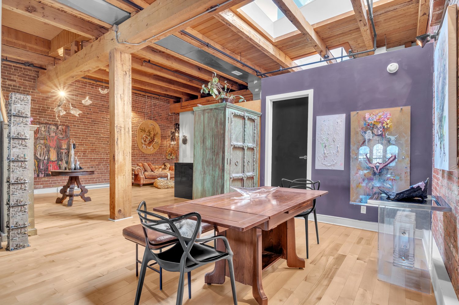 Open loft with exposed timber beams, brick and skylights