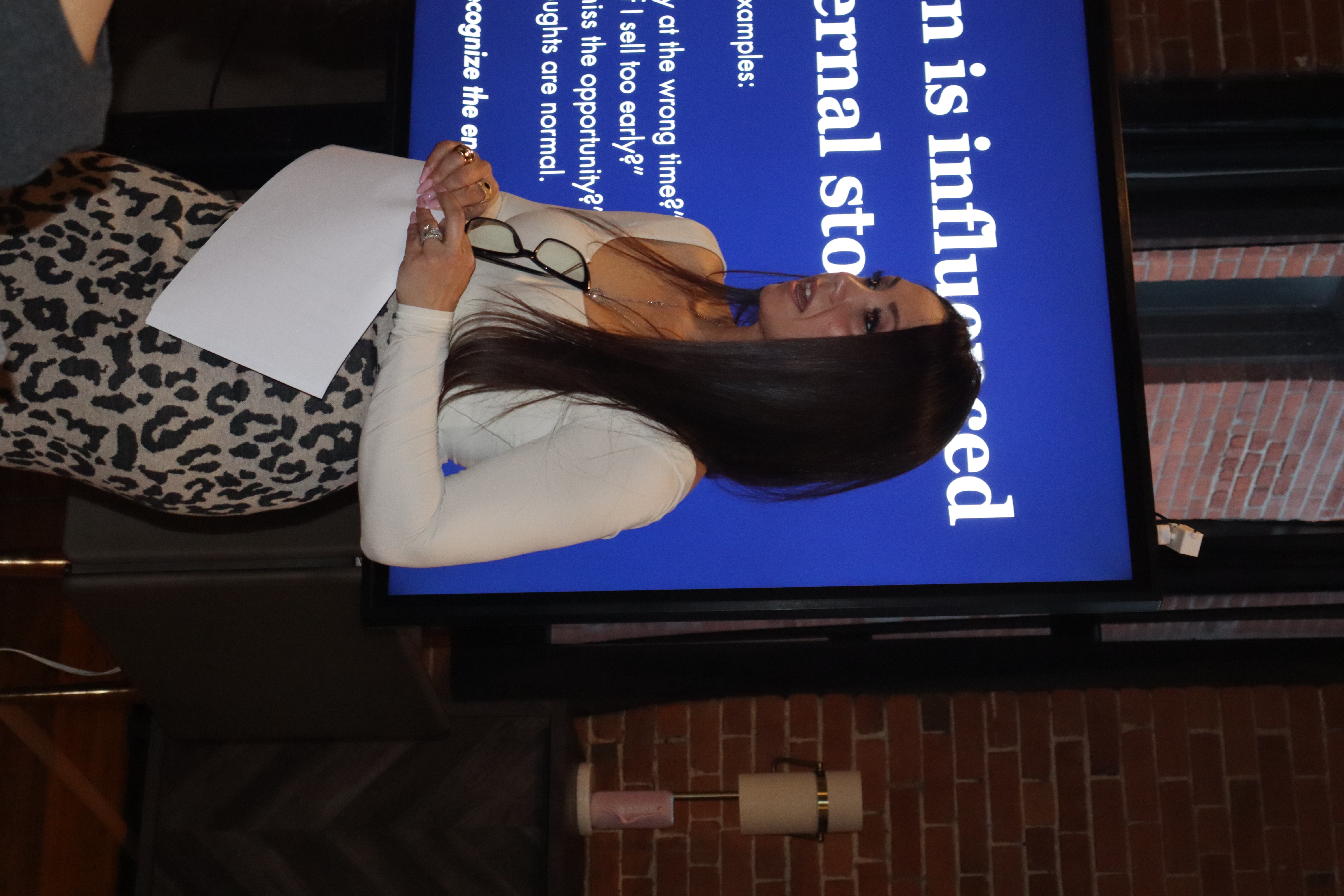 Shanna Giannakis presenting beside a blue screen